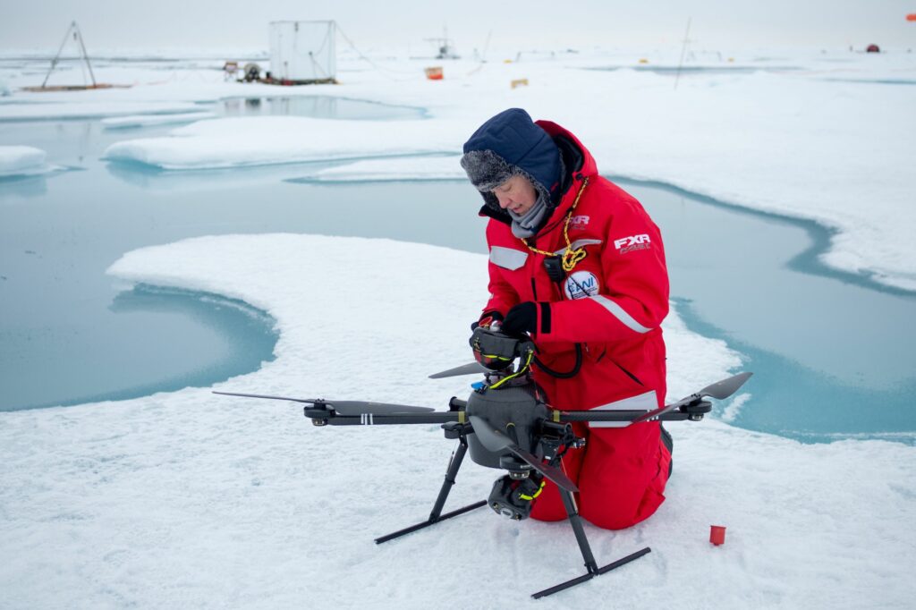 Researcher on the ice with a drone