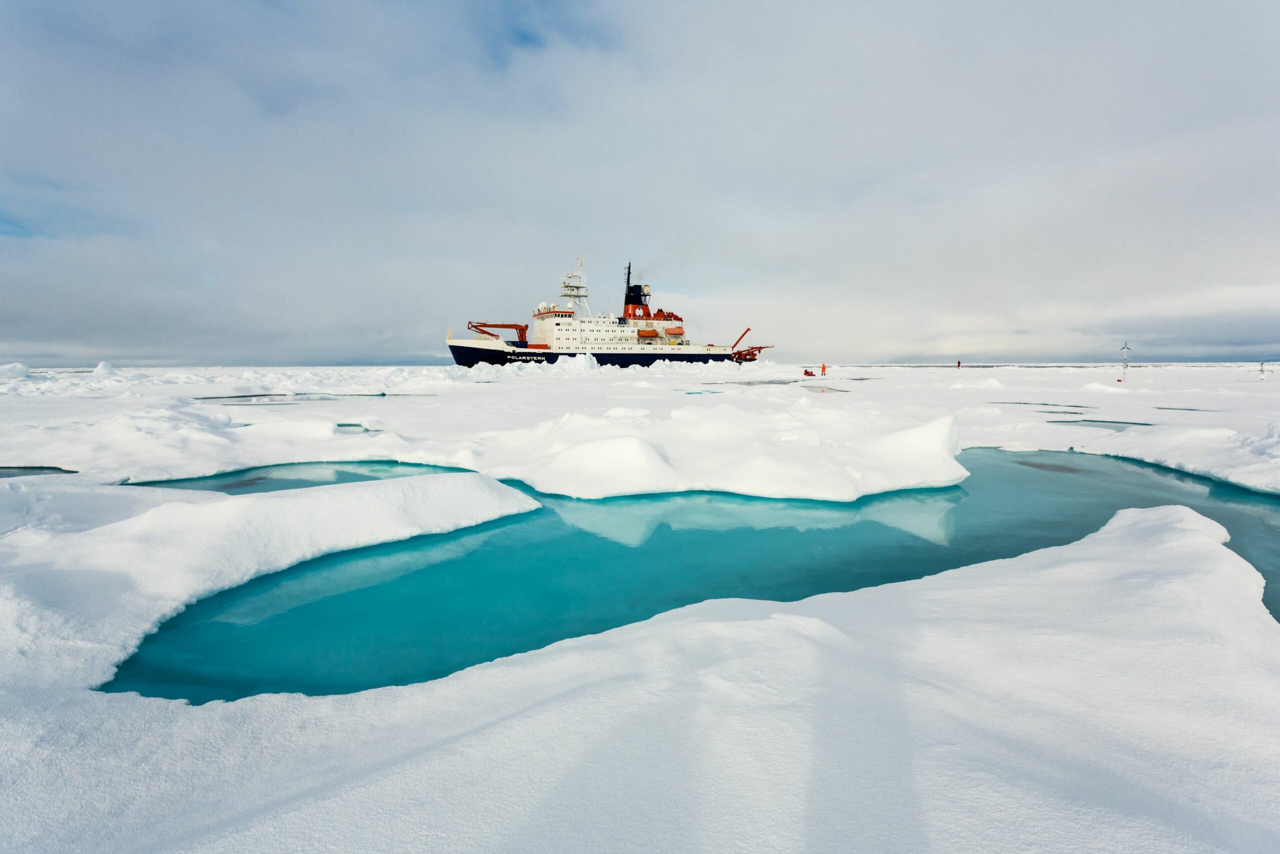 Polarstern auf Icestation: Im Vordergrund ist ein Schmelztümpel zu sehen.